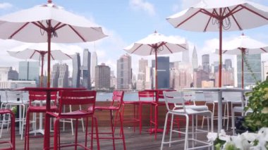 New York şehri kıyısı silueti, Manhattan şehir merkezi binaları, nehir kıyısındaki gökdelenler, doğu nehri kıyısındaki kafe şemsiyeleri. Hunters Point, Long Island, Queens, ABD 'den liman kenti manzarası.