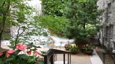 New York şehri hayatı, şehir parkı, Greenacre Park şelalesi. Amerikan Manhattan Midtown, ABD. Çiçek tarlasında tropikal çiçekler, ağaçlar yeşillik. NYC 51. Cadde 'deki yeşil vaha..