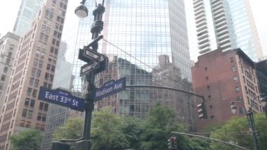 New York City kavşağı, Manhattan köşesi, Madison Bulvarı, sokak kavşağı tabelası. Midtown merkez bölgesi mimarisi, Birleşik Devletler. Tek yönlü ok işareti, gökdelenler. Düşük açı.