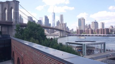 New York, Amerika Birleşik Devletleri - 30 Ağustos 2023 Manhattan şehir merkezi silueti Time Out Market 'ten deniz manzarası. Brooklyn Köprüsü yakınlarındaki Dumbo 'da Riverfront Atlıkarınca. Dünya Ticaret Merkezi gökdeleni.