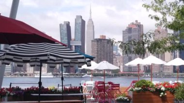 New York şehri kıyısı silueti, Manhattan şehir merkezi binaları, nehir kıyısındaki gökdelenler, doğu nehri suyu. Waterside şehir manzarası, Hunters Point rıhtım kolonları, Long Island, Queens. Birleşik Devletler.