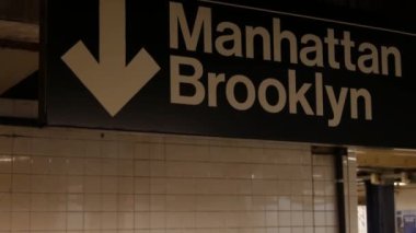New York metro istasyonu içi, Manhattan mesaj tabelası. Yeraltı metropolü. Birleşik Devletler metro nakliye navigasyonu. Bilgi levhası kamu yolcu tren yolu. Şehir merkezi ve Brooklyn yönü