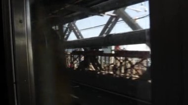 New York metro treni, Williamsburg Köprüsü. Kirli pencereden kamerayı sallamak. Manhattan metro ulaşımı, metropol trafiği. Yolcu yükseltilmiş demiryolu. East River, Midtown, NYC, ABD.