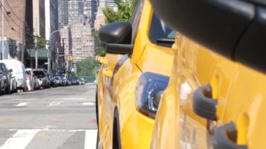 New York 'ta. Queens caddesindeki sarı taksiler. Long Island, LIC 'de bir sürü taksi var. Madalyon taksi ve Manhattan şehir merkezi şehir merkezi silueti. Yüksek binalı mimari.