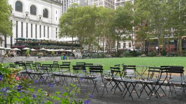 New York, ABD - 13 Eylül 2023: Manhattan şehir merkezi Bryant Park, 42 sokak ve 5. Cadde. ABD simgesi. Yeşillikte boş sandalye ve masa. Yeşil çimen.