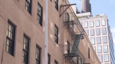 New York City klasik bina mimarisi. Şehir dışındaki konutlar. ABD 'de gayrimenkul. Amerika 'da tipik bir tuğla cephesi. Çatıdaki su kulesi, çatıdaki tank. Yangın merdiveni