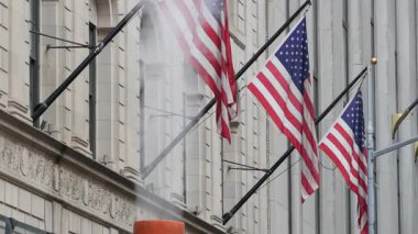 New York Şehri Birleşik Devletleri. Manhattan Şehir Merkezi Finans Bölgesi Şehir Mimarisi. Borsa 'nın yanındaki Wall Street' te Amerikan Bayrağı, Federal Hall binası, ABD Borsası. Sıcak buhar bacası.