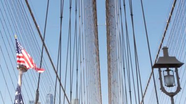 Brooklyn Köprüsü 'nden New York' a Amerikan bayrağı. Özgürlük, özgürlük, demokrasi ve bağımsızlığın vatansever sembolü, köprü kabloları. Amerika Birleşik Devletleri 'nin yıldızlı bayrağı rüzgarda savruluyor. ABD 'ye Seyahat.