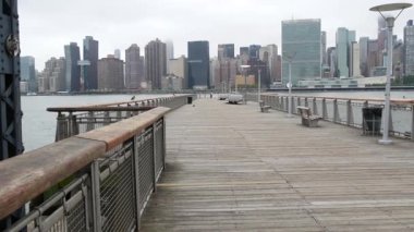 New York şehri kıyısı silueti, Manhattan şehir merkezi binaları, nehir kıyısındaki gökdelenler, doğu nehri suyu. Liman kenti manzarası, Gantry Plaza iskelesi, Long Island, Queens. Birleşik Devletler mimarisi.