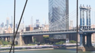Brooklyn Köprüsü manzaralı New York City Manhattan Köprüsü. Şehir merkezindeki Empire State binası. ABD 'yi gezmek, turistik yerleri gezmek. New York Skyline şehir manzarası. Doğu Nehri suyunun üzerindeki ikonik mimari kablolardan..