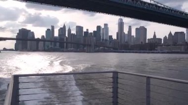 Feribot ile New York City şehir merkezinin silueti. Manhattan ve Brooklyn köprüsü. Feribottan Dünya Ticaret Merkezi gökdelenine. Doğu nehri kıyısı manzarası, nehir kenarındaki binalar, ABD.