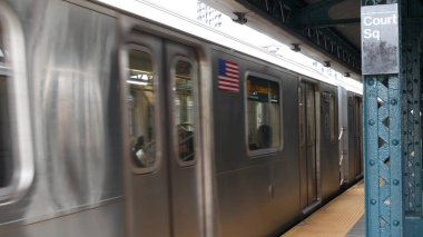 New York City, ABD - 29 Ağustos 2023: metro istasyonu. Metro treni toplu taşıma platformunda. Queens 'teki Court Square demiryolunda yükseltilmiş. New York yolcusu tren yolu trafiği, Long Island
