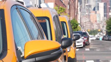 New York 'ta. Queens caddesindeki sarı taksiler. Long Island, LIC 'de bir sürü taksi var. Madalyon taksi ve Manhattan şehir merkezi şehir merkezi silueti. Yüksek binalı mimari.