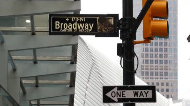 Broadway caddesi tabelası, Manhattan şehir merkezi finans bölgesi mimarisi. New York City, Fulton caddesi köşe tabelası. Dünya Ticaret Merkezi yakınlarında sarı trafik ışığı. Metro girişi. Tek yönlü ok