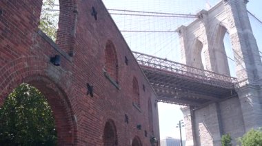 Dumbo 'dan New York City Brooklyn Köprüsü' ne. Kırmızı tuğla duvar, eski tarihi tütün deposu, Market ve Tiyatro. Düşük açı. Sembolik simge altında kemerli pencereler. Amerika Birleşik Devletleri, ABD mimarisi