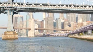 New York City Manhattan Köprüsü 'nden Brooklyn' e. Rıhtım şehir merkezi, 35. İskeleden ABD finans bölgesi gökdelenleri. Doğu nehri ikonik manzarası, sabah gün batımı. Nehir kenarı mimarisi.