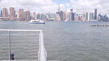 Feribottan New York City silueti. Manhattan şehir merkezinde, feribottan yükselen gökdelenler. Doğu nehri kıyısı manzarası, nehir kenarı mimarisi, ABD. Empire State, Chrysler Binası.