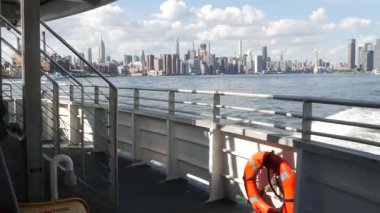 Feribottan New York City silueti. Manhattan şehir merkezinde, feribottan yükselen gökdelenler. Doğu nehri kıyısı manzarası, ABD mimarisi. Empire State, Chrysler Binası. Kamu güvenliği can simidi.
