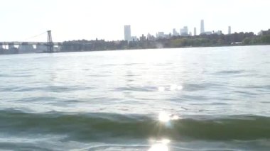 Feribottan New York City silueti. Manhattan şehir merkezindeki gökdelenler feribottan görünüyor. Doğu nehri kıyısı manzarası, nehir kıyısındaki binalar ABD suları yakınında. Williamsburg Köprüsü