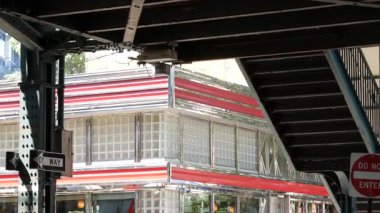 New York metrosu, metropol köprüsü, caddenin üstündeki metro yolu. Demiryolu taşımacılığı. Demiryolu hattı. Eski kafe, restoran. Court Square, Long Island City, Queens, ABD