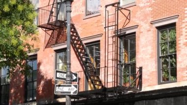 New York City klasik bina mimarisi, Manhattan, ABD. Şehir dışındaki konutlar. Birleşik Devletler 'de gayrimenkul. Tipik kırmızı tuğla cephesi. Yangın merdiveni. Tek yönlü ok işareti.