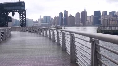New York City rıhtımı silueti, Manhattan şehir merkezi, nehir kıyısındaki gökdelenler, doğu nehri suyu. Long Island, Queens 'teki Gantry Plaza rıhtımından rıhtım manzarası. Birleşik Devletler mimarisi.