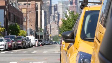 New York 'ta. Queens caddesindeki sarı taksiler. Long Island, LIC 'de bir sürü taksi var. Madalyon taksi ve Manhattan şehir merkezi şehir merkezi silueti. Yüksek binalı mimari.