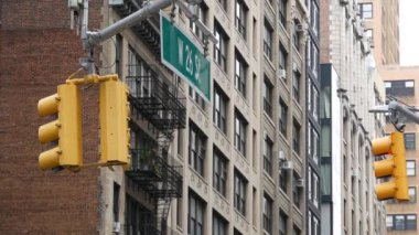 New York caddesi kavşağı, sarı trafik ışığı, ulaşım yolu kavşağı, Birleşik Devletler. Konut mimarisi. New York Emlak, yangın merdivenli kırmızı kahverengi tuğlalı ev. Manhattan.