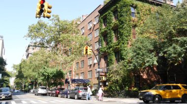 New York City, ABD, 6 Eylül 2023 Manhattan şehir merkezi Irving sokak köşesi, kavşak, Gramercy, ABD. İnsanlar yayalar. Sarı taksi. Sarmaşık yapraklarıyla kaplı kırmızı tuğladan ev