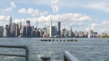 Feribottan New York City silueti. Manhattan şehir merkezinde, feribottan yükselen gökdelenler. Doğu nehri kıyısı manzarası, nehir kenarı mimarisi, ABD. Chrysler Binası. Mavi gökyüzü.