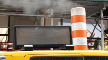 New York caddesinde buhar sızıntısı, turuncu buhar borusu yığını. Pipo dumanı. Con Edisons Buhar Operasyonları Sistemi, 5. Cadde, Manhattan Midtown. Sarı taksi ve iskele, ABD