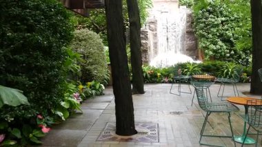 New York şehri hayatı, şehir parkı, Greenacre Park şelalesi. Amerikan Manhattan Midtown, ABD. Eğlence bölgesi yaz çiçekleri, ağaçlar yeşillik. Boş sandalyeler ve masalar. New York 'ta yeşil vaha.