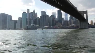 New York City, Manhattan şehir merkezi feribottan ufuk çizgisi. Brooklyn Köprüsü. Feribottan Dünya Ticaret Merkezi gökdelenine. Doğu nehri kıyısı manzarası, nehir kenarındaki binalar, ABD.
