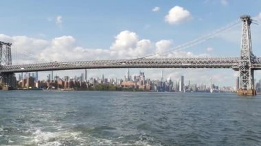 Feribottan New York City silueti. Manhattan şehir merkezindeki gökdelenler feribottan görünüyor. Doğu nehri kıyısı manzarası, nehir kıyısındaki binalar ABD suları yakınında. Williamsburg Köprüsü