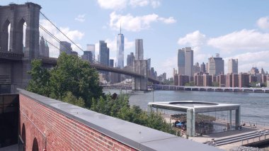 New York, Amerika Birleşik Devletleri - 30 Ağustos 2023 Manhattan şehir merkezi silueti Time Out Market 'ten deniz manzarası. Brooklyn Köprüsü yakınlarındaki Dumbo 'da Riverfront Atlıkarınca. Dünya Ticaret Merkezi gökdeleni.