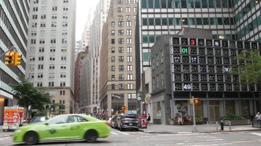 New York, Amerika Birleşik Devletleri - 9 Eylül 2023 Manhattan Şehir Merkezi Finans Bölgesi Su ve John Caddesi kavşağı. ABD karayolu trafiği. Sarı taksi, millet. Dijital saat, bingo tahtası.