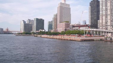 New York, ABD - 31 Ağustos 2023 Long Island silueti, Hunters Point iskelesi, feribot. Feribottan yükselen gökdelenler. Doğu nehri kıyısı manzarası, nehir manzaralı binalar mimarisi..