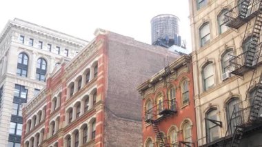 Broadway caddesi yakınlarındaki New York City Manhattan Soho moda bölgesi. Amerikan şehir binası cephesi, eski klasik Amerikan mimarisi. NYC 'de ikamet eden gayrimenkul. Çatıda su deposu var.