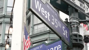 New York City kavşağı, Manhattan Broadway sokak kavşağı tabelası. New York şehir merkezi mimarisi, Herald Square Park, 6. Cadde, ABD. Amerikan bayrağı. Tek yönlü ok işareti.