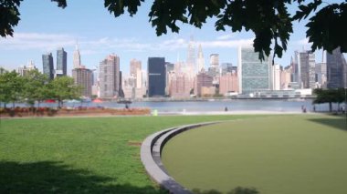New York şehri kıyısı silueti, Manhattan şehir merkezi binaları, nehir kıyısındaki gökdelenler, doğu nehri suyu. Long Island, Queens 'teki Hunters Point' ten deniz kenarı manzarası. Birleşik Devletler mimarisi.