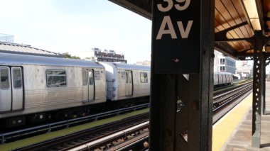 New York, ABD - 2 Eylül 2023 Metro İstasyonu. Metro treni toplu taşıma platformunda. Queens 'te 39. Cadde' de yüksek bir demiryolu var. New York yolcusu tren yolu trafiği, Long Island.