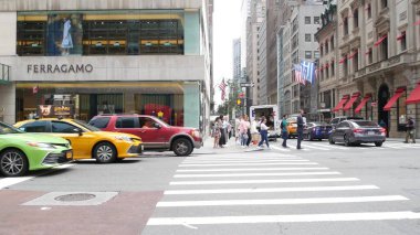 New York, Birleşik Devletler - 11 Eylül 2023 Manhattan Midtown Caddesi, Beşinci Cadde. Amerikan şehir trafiği. Sarı ve yeşil boro taksi. - İnsanlar. Butik moda lüks mağazaları, Amerikan alışveriş merkezleri.