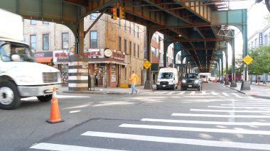 New York, Birleşik Devletler - 31 Ağustos 2023: sokağın üstündeki metro yükseltilmiş. Yolun üzerindeki Metropolitan Köprüsü, Queens. Long Island metro hattı, Court Meydanı. Metalik demiryolu altında arabalar. NYC şehir hayatı