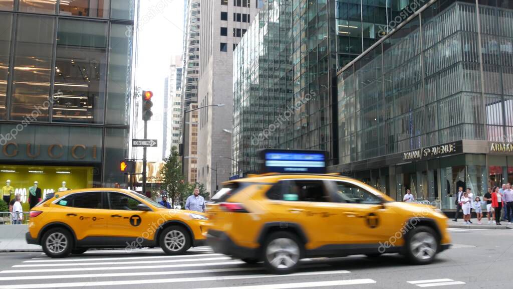 New York City, United States - 13 Sept 2023: Manhattan Midtown street, Fifth 5 avenue. American urban road car traffic. Yellow taxi in USA. People. Boutique fashion stores for shopping, Gucci, Armani.