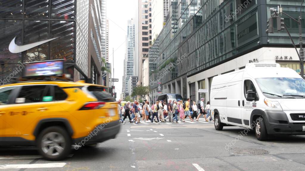 New York City, United States - 11 Sept 2023: Manhattan Midtown street, Fifth 5 avenue, 5th ave, American road car traffic, Yellow taxi cab. People pedestrians, zebra crosswalk, crossroad intersection.