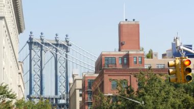 Brooklyn Köprüsü 'nden New York City Manhattan Köprüsü manzarası. Kırmızı kahverengi tuğlalı bina pencereleri. Klasik NYC mimarisi. Brooklyn 'deki Birleşik Devletler gayrimenkulleri. Sarı trafik ışığı, arabalar...