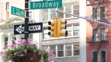 Broadway sokak tabelası, Manhattan şehir merkezi mimarisi, New York köşesi. Sarı trafik ışığı. Madison Square Park yakınlarındaki Flatiron bölgesinde. 23. Cadde, Bway ve 5. Cadde 'nin kesiştiği yerde. Tek yön