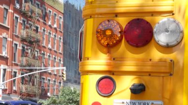 New York Manhattan caddesinde sarı okul otobüsü, şehir yolunda okul otobüsü kamyonu. Çocuk eğitim ve ulaşım, ABD. Amerikan okul servisi, 10 Avenue Chelsea kırmızı tuğlalı ev, Amerika Birleşik Devletleri.