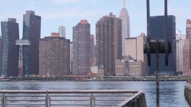 New York şehri kıyısı silueti, Manhattan şehir merkezi binaları, nehir kıyısındaki gökdelenler, doğu nehri suyu. Liman kenti manzarası, Gantry Plaza Park, Long Island, Queens. Birleşik Devletler mimarisi.