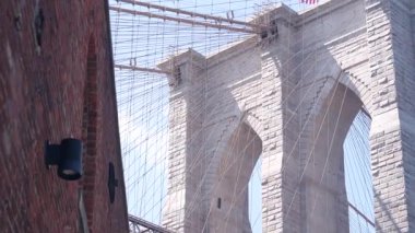 Dumbo 'dan New York City Brooklyn Köprüsü' ne. Kırmızı tuğla duvar, eski tarihi tütün deposu, Market ve Tiyatro. Düşük açı. Sembolik simge altında kemerli pencereler. Amerika Birleşik Devletleri, ABD mimarisi